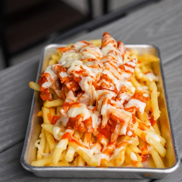 Hot and Loaded fries topped with buffalo chicken tenders, queso, mozzarella, and sauce
